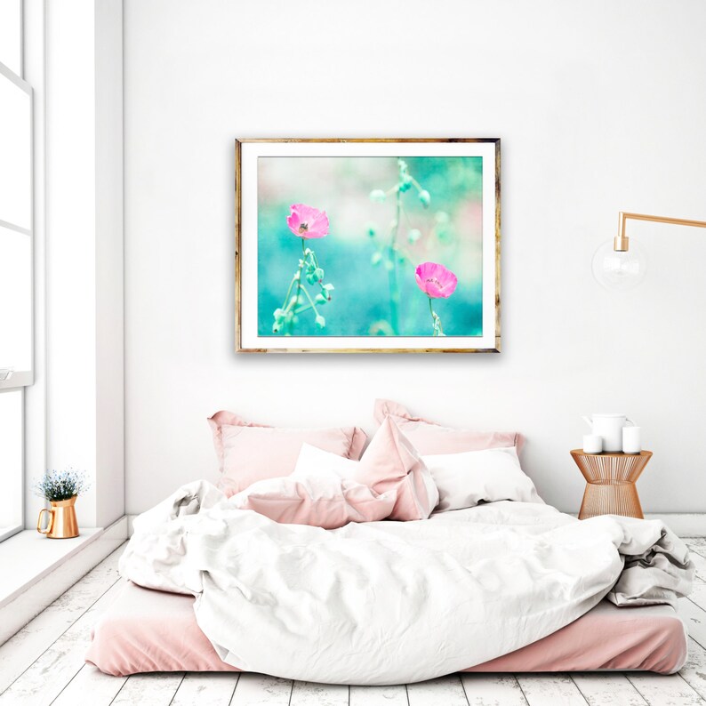 May include: A framed print of two pink flowers with green stems against a turquoise background.