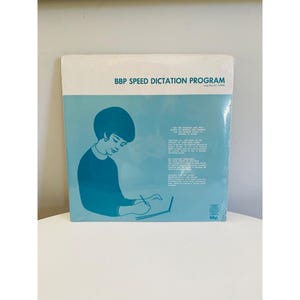 Może przedstawiać: Okładka winylowej płyty z programem BBP Speed Dictation Program. Okładka jest w kolorze niebieskim i białym i przedstawia kobietę w niebieskiej sukience, która pisze w notesie. Tekst na okładce brzmi "BBP Speed Dictation Program Long Play 33 1/3 RPM".