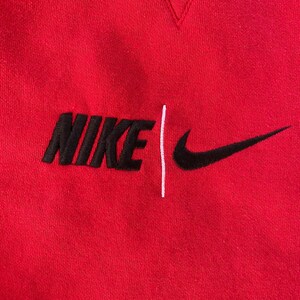 May include: Red sweatshirt with a black embroidered Nike logo and a white vertical line.