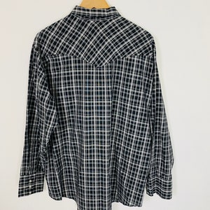 May include: A black and white plaid long-sleeve shirt with a pointed collar and button closure.
