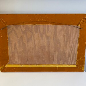 May include: The back of a rectangular picture frame with a gold velvet border. The frame is made of wood and has a wire hanger attached to the back.
