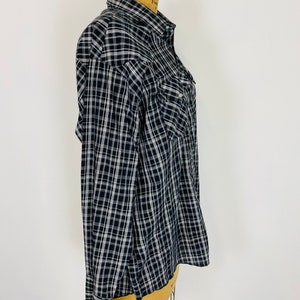 May include: A black and white plaid long-sleeved button-up shirt with a single chest pocket.