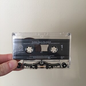 May include: A black cassette tape with the title "Debbie Harry/Rockbird" and the song titles "I Want You", "French Kissin", "Buckle Up", and "In Love With Love". The tape is labeled "Geffen" and "M5G 24123".