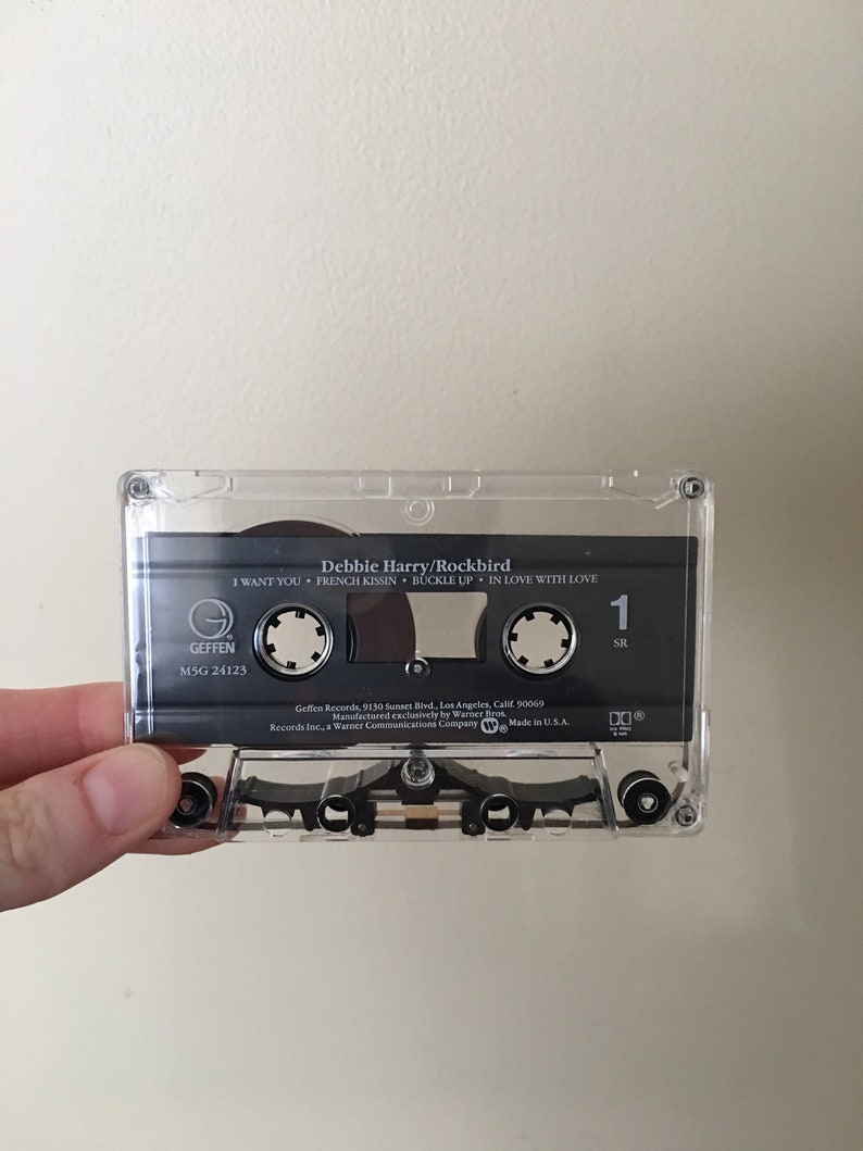 May include: A black cassette tape with the title "Debbie Harry/Rockbird" and the song titles "I Want You", "French Kissin", "Buckle Up", and "In Love With Love". The tape is labeled "Geffen" and "M5G 24123".