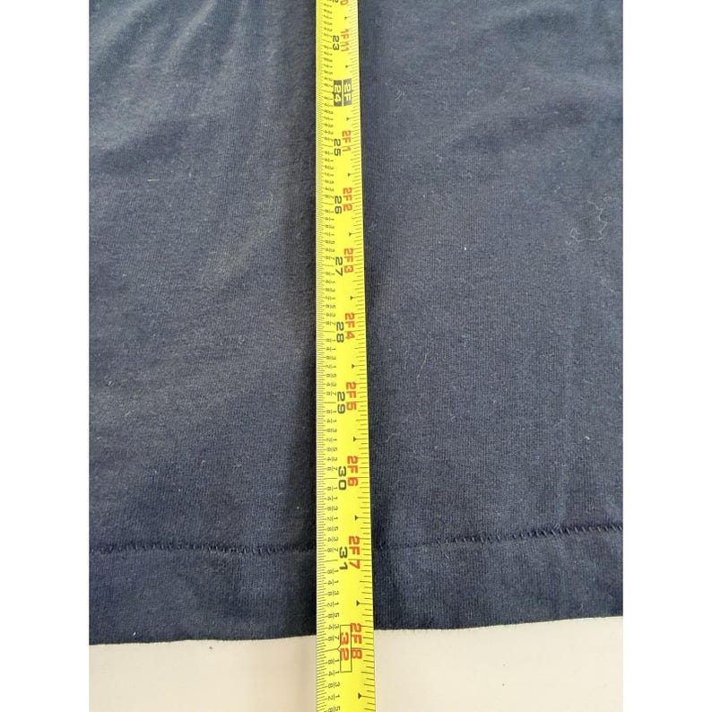 Może przedstawiać: Granatowa tkanina z ż&oacute;łtą miarką. Taśma pokazuje pomiary do 81 cm. Tkanina jest gładka i wydaje się być elementem odzieży lub tkaniny.