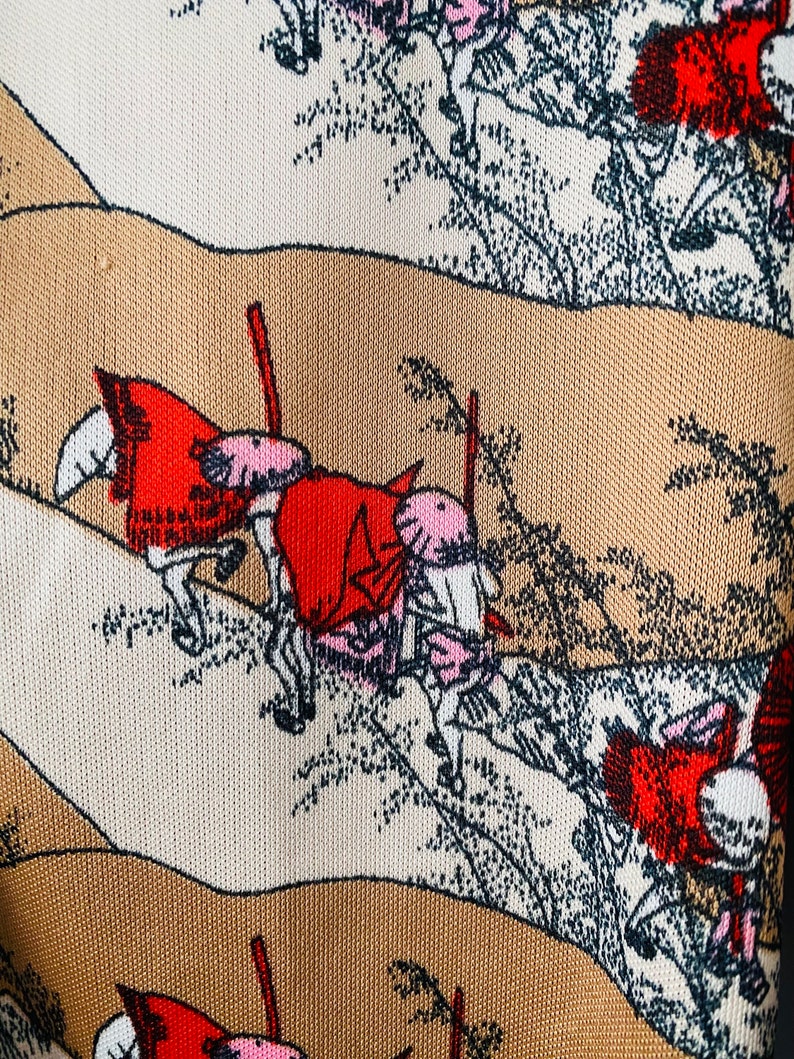 May include: Close-up of a fabric with a repeating pattern of a landscape scene. The design features figures on horseback, rendered in red, pink, and white, set against a backdrop of beige and brown hills and stylized trees.
