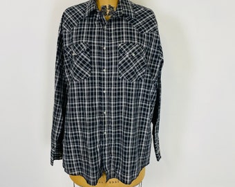 May include: A black and white plaid long-sleeved shirt with a button-down collar and two chest pockets.