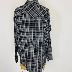 May include: A black and white plaid long-sleeve shirt with a pointed yoke in the back.