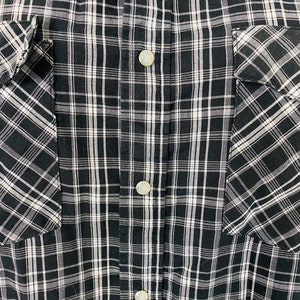 May include: Black and white plaid button-up shirt with two chest pockets.