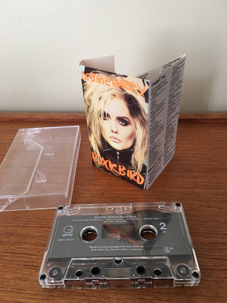 May include: A cassette tape with a clear plastic case. The tape is labeled "Debbie Harry/Rockbird" and features the song titles "You Got Me In Trouble", "Free To Fall", "Rockbird", "Secret Life", and "Beyond The Limit". The tape is a Geffen Records release with the catalog number MSG 24123. The tape is produced and arranged by Seth Justman and is copyrighted 1986 by The David Geffen Company.