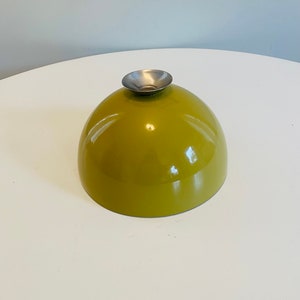 May include: A green ceramic bowl with a silver metal rim. The bowl is round and has a smooth, glossy finish.