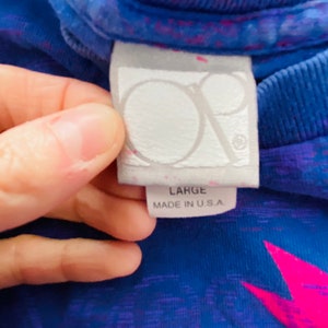 May include: A blue and pink tie-dye t-shirt with a white tag that says "Large" and "Made in U.S.A."