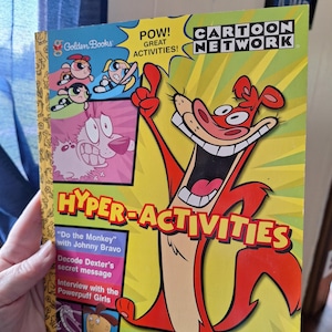 May include: A Golden Books "Hyper-Activities" book featuring Cartoon Network characters. The cover has a yellow background with the words "POW! GREAT ACTIVITIES!" and "CARTOON NETWORK". The book includes "Do the Monkey" with Johnny Bravo and more.