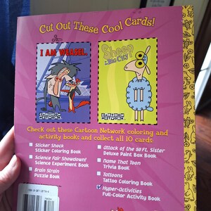 May include: A Cartoon Network activity book with a pink cover featuring cartoon characters. The book includes the text "Cut Out These Cool Cards!" and lists various activity books. The back cover has a barcode and the price.