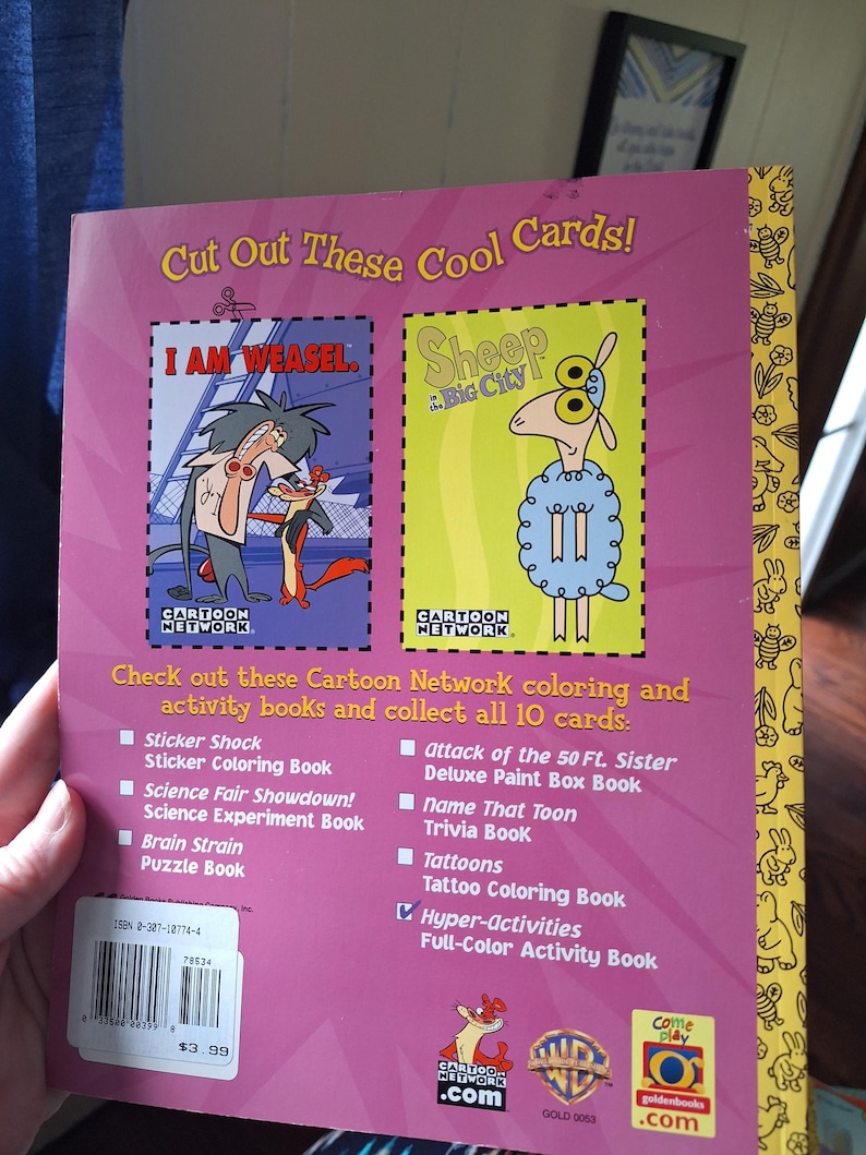 May include: A Cartoon Network activity book with a pink cover featuring cartoon characters. The book includes the text "Cut Out These Cool Cards!" and lists various activity books. The back cover has a barcode and the price.
