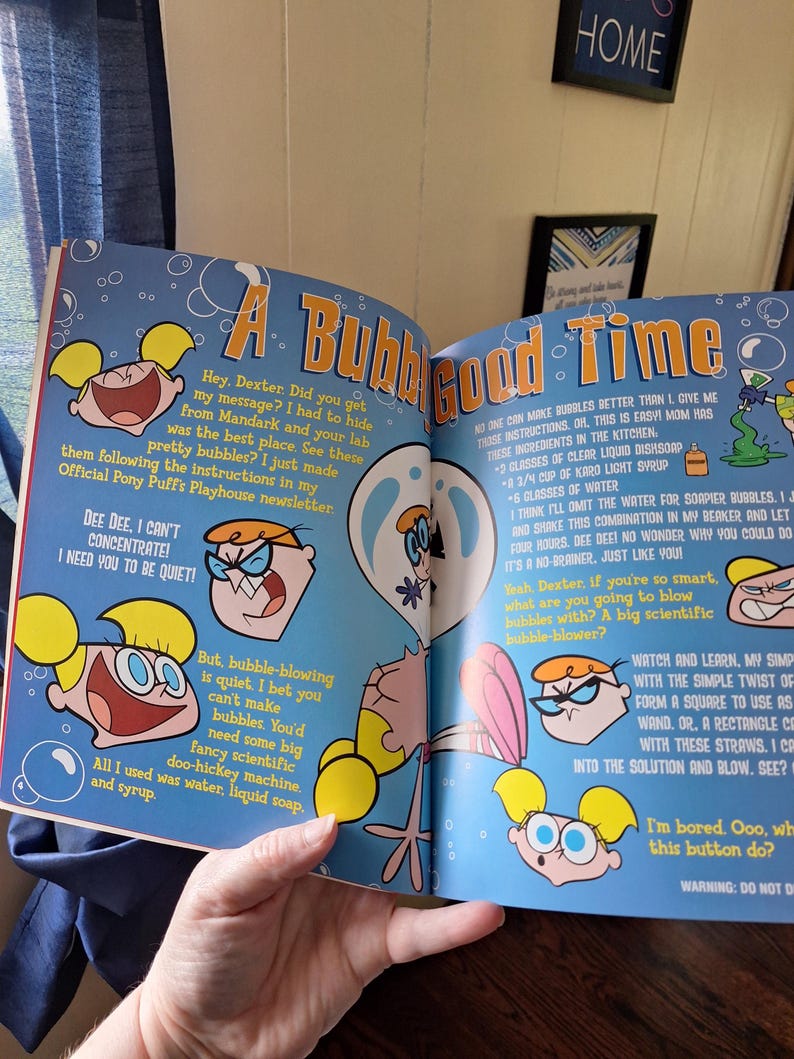 May include: A colorful page from a Dexter's Laboratory comic book. The page features cartoon illustrations of Dexter and Dee Dee, along with bubble-blowing instructions. Text includes the title "A Bubble Good Time."