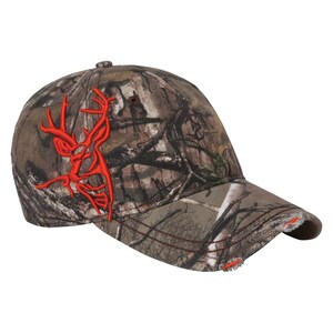 May include: Camouflage baseball cap with a red embroidered deer logo. The cap has a distressed brim.