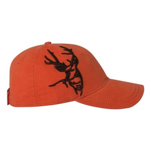 May include: An orange baseball cap with a black embroidered deer design.