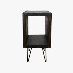 May include: A dark brown wooden end table with a square open shelf and hairpin legs.