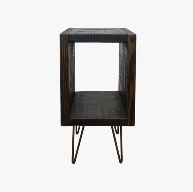 May include: A dark brown wooden end table with a square open shelf and hairpin legs.