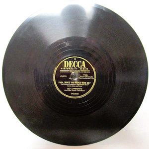 May include: A vintage black vinyl record with a gold and black label. The label reads "DECCA PERSONALITY SERIES" and features the song title "PAPA, WON'T YOU DANCE WITH ME?" by Guy Lombardo and His Royal Canadians. The record is a 12-inch disc.