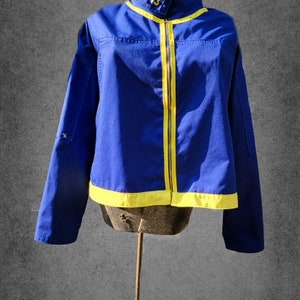 May include: A blue jacket with yellow trim and a zipper closure. The jacket has a number "13" on the front.
