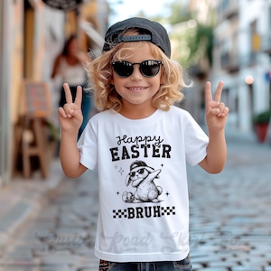 May include: A white t-shirt with a black and white illustration of a bunny wearing sunglasses and a hat. The text "Happy Easter" and "Bruh" is printed on the shirt.