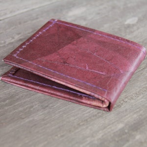 Cartera de hojas en color vino tinto y morado, plegada una vez.
