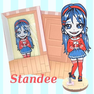 May include: A cartoon figure with blue hair, red headband, and red and blue outfit. The figure is standing on a wooden base with a knife. The word "Standee" is written in red. The figure is also in a framed picture.