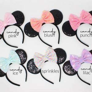 May include: Six headbands with black sequin ears and colorful sequin bows. The bows are labeled candy pink, candy blush, candy punch, candy ice, sprinkles, and candy lilac. Each headband features a thin black band and two round ears.
