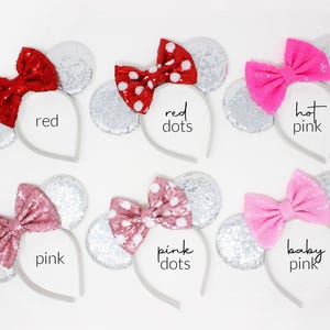 May include: Six headbands with silver sequin ears and various bows. The bows are red, red with white dots, hot pink, pink, pink with white dots, and baby pink. Each headband is labeled with its respective color name in black text.