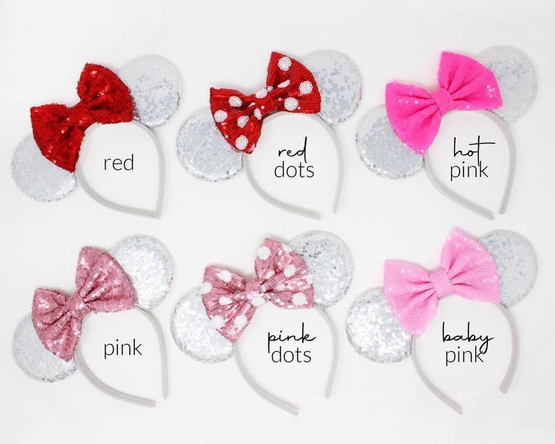 May include: Six headbands with silver sequin ears and various bows. The bows are red, red with white dots, hot pink, pink, pink with white dots, and baby pink. Each headband is labeled with its respective color name in black text.