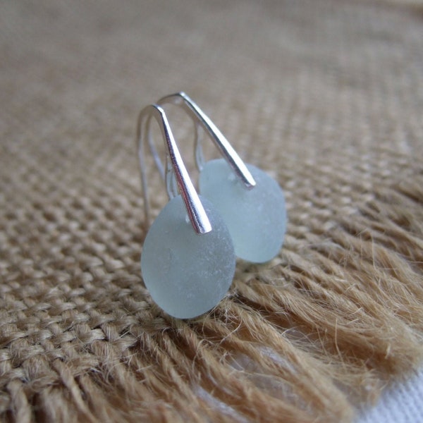 May include: A pair of silver dangle earrings with light blue sea glass stones.