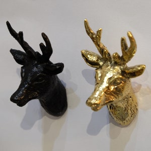 May include: Two deer head wall hooks, one black and one gold.