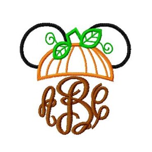 May include: A brown monogram with the letters "A B E" inside a pumpkin-shaped design with green leaves and black Mickey Mouse ears.