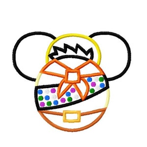May include: A white and orange embroidered design of a cartoon character with a yellow halo, a bow, and a belt. The character has large black ears and a face with colorful polka dots.