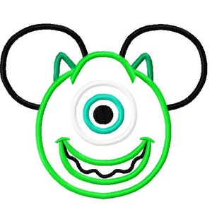 May include: Green one-eyed monster with a toothy grin, wearing black Mickey Mouse ears.