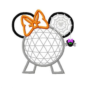 Puede incluir: Una esfera blanca y gris con un diseño de telaraña negra en un lado y un lazo naranja en el otro. La esfera está sobre dos patas grises y tiene una araña negra con un lazo morado colgando de la telaraña.