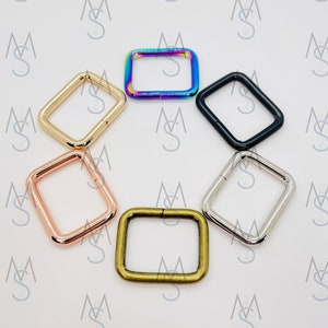 May include: Six different colored metal D-rings. The rings are square shaped and have a polished finish. The colors are rainbow, gold, rose gold, silver, black, and bronze.