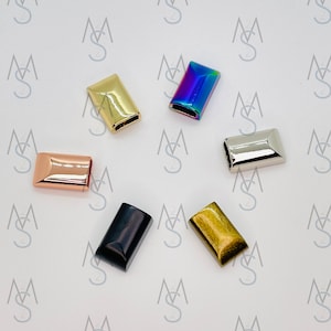 May include: Assortment of six metal slider buckles in various colors, including gold, silver, rose gold, black, and iridescent.