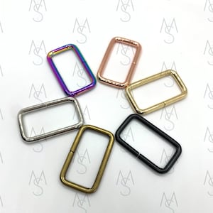 May include: Six different colored metal D-rings. The rings are in a variety of colors, including silver, gold, black, and rainbow.