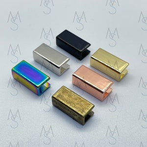 Könnte beinhalten: Sortiment von sechs Metall-Schiebeschließen in verschiedenen Ausführungen, darunter Schwarz, Silber, Gold, Roségold, Regenbogen und Antikmessing.