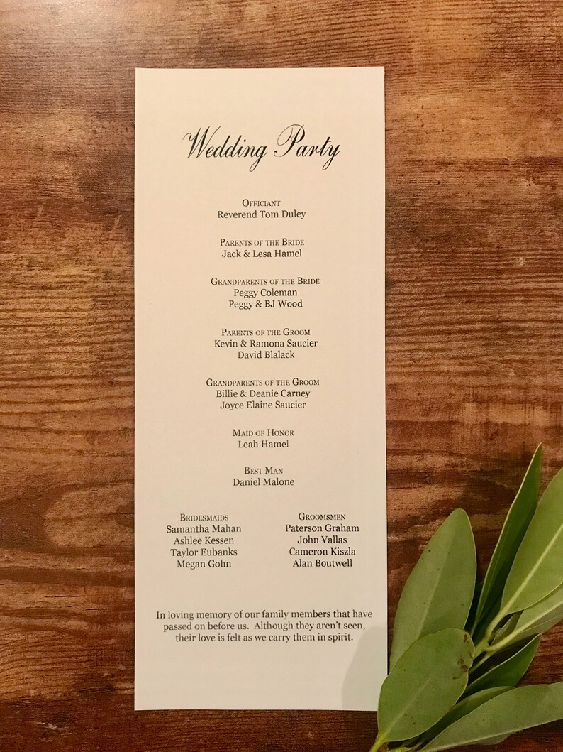 Pode incluir: Uma lista de casamento com os nomes do celebrante, dos pais da noiva e do noivo, dos av&oacute;s da noiva e do noivo, da dama de honra, do padrinho, das damas de honra e dos padrinhos. O texto na parte inferior diz: "Em mem&oacute;ria carinhosa de nossos familiares que nos precederam. Embora n&atilde;o os vejamos, sentimos o seu amor enquanto os carregamos em nossos cora&ccedil;&otilde;es."