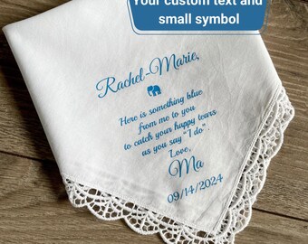 May include: White handkerchief with blue text and a lace edge. The text includes a name, a message, and a date. The handkerchief is a wedding keepsake.