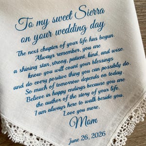 May include: White handkerchief with blue script, including the text "To my sweet Sierra on your wedding day." The handkerchief has a delicate lace trim and a message from "Mom," dated June 26, 2026.