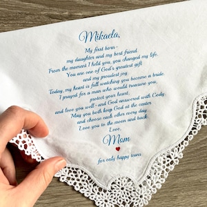 May include: White handkerchief with blue script and a delicate lace edge. The text includes a heartfelt message to Mikaela from her mother, with a small red heart. A touching keepsake.