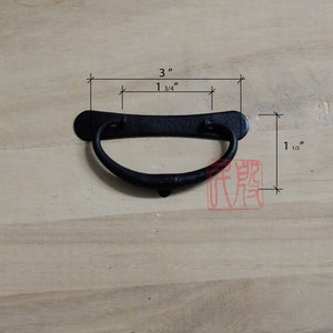 Könnte beinhalten: Schwarzer Metall-Schubladenzug mit einer rechteckigen Form von 7,6 cm x 3,8 cm. Der Zug hat einen gebogenen Griff.