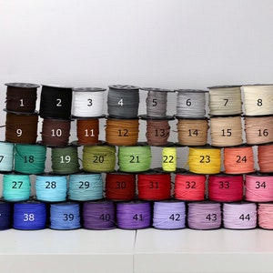 May include: A collection of 46 spools of thread, each wound with a different color of thread. The spools are arranged in a pyramid shape, with the numbers 1 through 46 printed on the front of each spool.