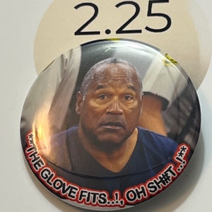 May include: A round button with a photo of a man in a blue shirt. The text on the button reads "THE GLOVE FITS...!, OH SH*T! ...".