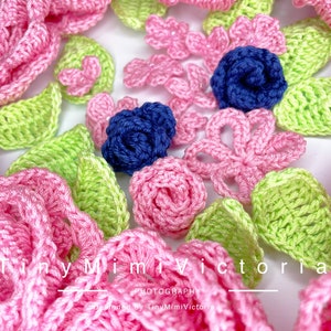 May include: A collection of crocheted flowers in pink, green, and blue. The flowers are arranged in a circle on a white background. The text "Tiny Mimi Victoria Photography" is visible at the bottom of the image.